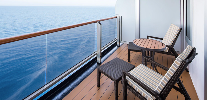 a deck with chairs and tables on it by the water